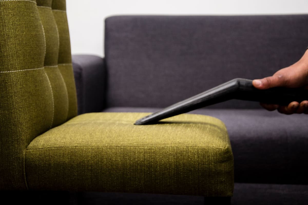 Aspiration en profondeur de l'assise d'un fauteuil en tissu vert
