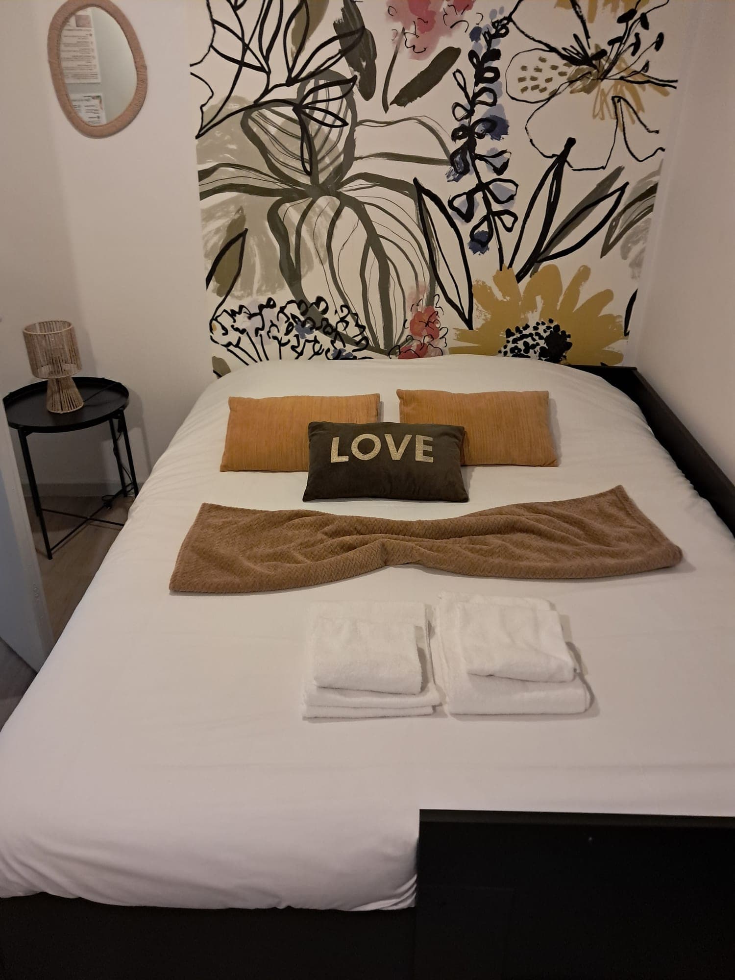 Bedroom made ready: aligned cushions, throw and folded towels on the bed
